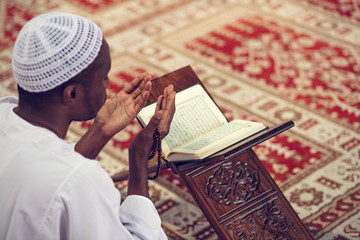 African Muslim Man Making Traditional Prayer To God While Wearing Dishdasha - obrazy, fototapety, plakaty