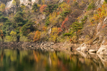 Fototapeta na wymiar In autumn, rocks and mountains are reflected in the water