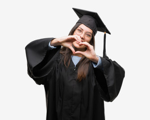 Young hispanic woman wearing graduated cap and uniform smiling in love showing heart symbol and...