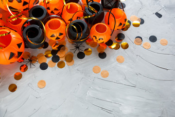 Halloween preparation. Decorative orange pumpkins and black cauldrons  on a gray grunge background....