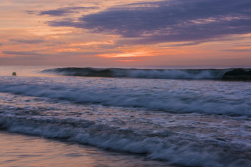 Amazing sunrise viewed from Avon By The Sea beach featuring dramatic sky on the background and waves on the foreground