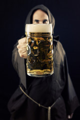 A bearded friar (Franciscan religious man) offering a giant mug of beer to the viewer, made even...