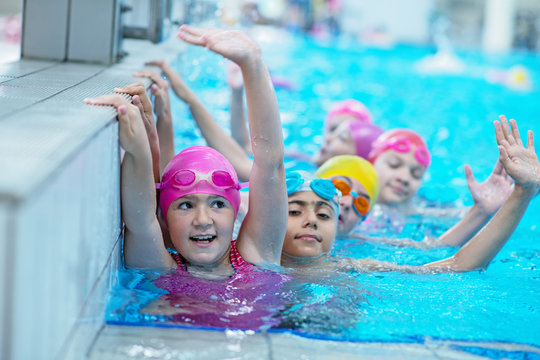 happy kids at the swimming pool. young and successful swimmers pose.