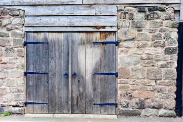 wooden double doors and stone wall                    