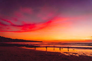 Colorful sunset or sunrise at tropical beach with ocean and waves