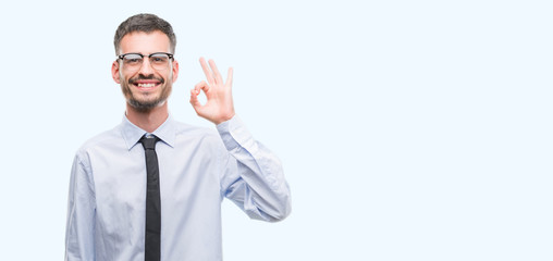 Young business man doing ok sign with fingers, excellent symbol