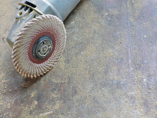 Close up of a grinder, its sander wheel / disc, and saw dust