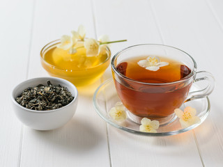 Honey, herbal tea and jasmine on a white wooden table. The composition of the morning Breakfast.