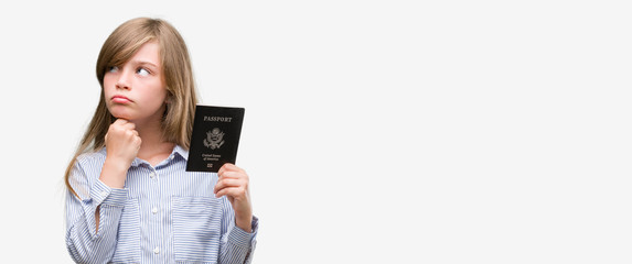 Young blonde toddler holding american passport serious face thinking about question, very confused idea