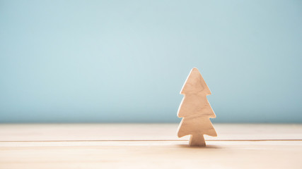 Wood christmas tree on table with blue pastel color background, copy space, minimal idea concept.