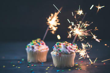 two cupcakes with sparklers
