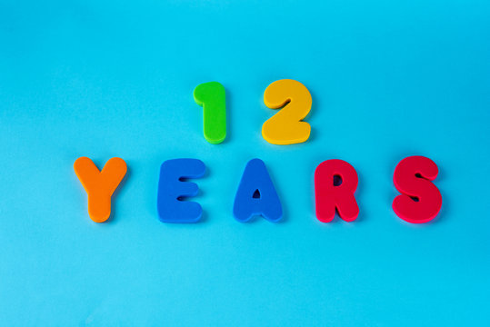 12 years old celebrating classic logo. Colored happy anniversary 12 th cute numbers on blue background. Bat mitzvah invitation Greetings celebrates card. Traditional digits of ages.Flat lay.