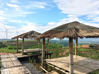 Bamboo shelter over windmill field background