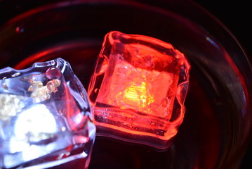 In a glass of champagne floating a white ice cube and a red ice cube and very bright and romantic
