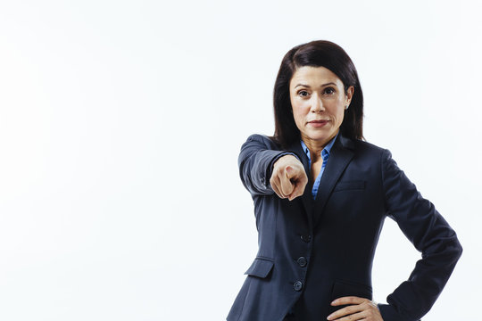 Powerful boss making a decision, portrait of a confident woman pointing at camera, isolated on white studio background
