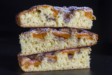 Homemade organic apricot pie dessert ready to eat . Apricot tart with walnut on black background