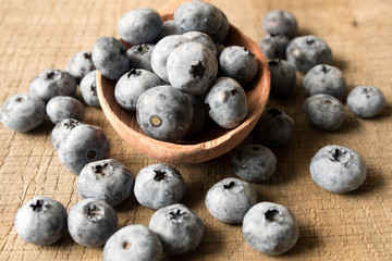 Fresh blueberries on an old wooden table in a wooden spoon. Close up. The concept of natural food