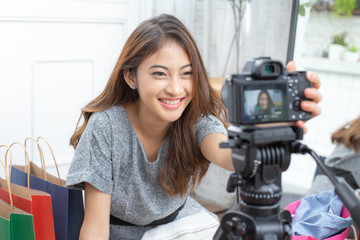 Asian attractive girl checking to camera for record video. Woman using social media to promote her...