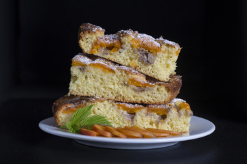 Homemade organic apricot pie dessert ready to eat . Apricot tart with walnut on black background