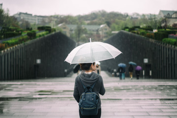 Young asian woman traveler in lonely feeling holding umbrella traveling in Ewha womans university...