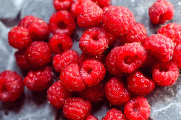 a lot of raspberry from close range on a stone grey background