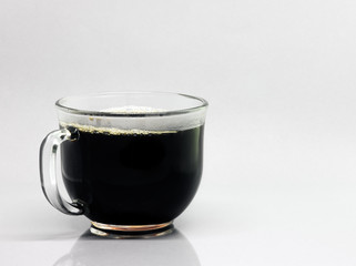 Cup of black coffee in a clear coffee cup on a white background.