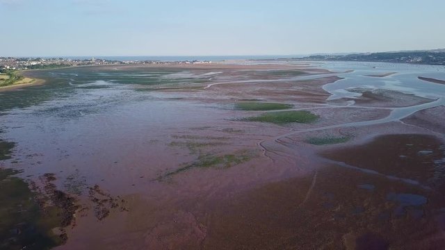 Aerial view of the town and beach life in Lympstone, a coastal town in England. Water plants are visible and the landscape is amazingly breathtaking.