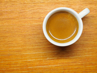 Cup of Espresso coffee on wood board background, Arabica with crema