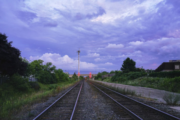 Railway tracks at dramatic summery sunset in a Canadian suburbia
