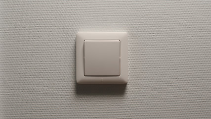 Power button on a light-grey wall - Front view