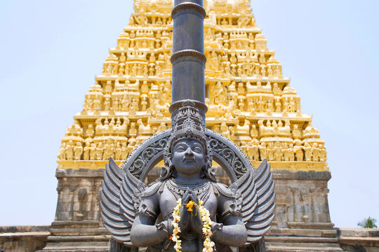 Garuda, the vehicle of the Hindu god Vishnu facing the Chennakesava temple, Belur, Karnataka. East Gopura, tower over entrance, is in the background.