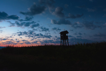 Hunting tower, hide, lookout in dusk with cloudscape