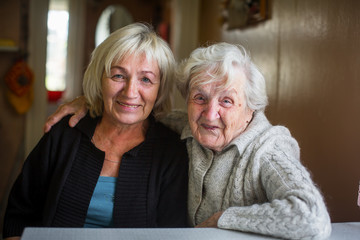 Portrait of an elderly woman with her adult daughter.