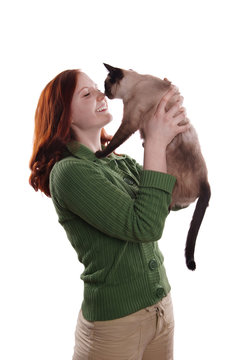 happy young woman rubbing nose with siamese cat