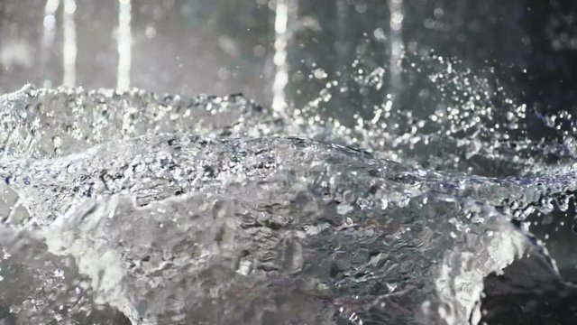 Close-up shot of water drops of fountain in the summer park. Slow motion. HD