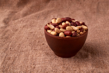 dry peanuts background. close up dry peanuts in clay bowl. Space for pext. Copyspace
