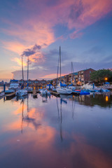 Fototapeta na wymiar Sunset over boats on the waterfront in Canton, Baltimore, Maryland
