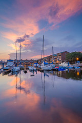 Fototapeta na wymiar Sunset over boats on the waterfront in Canton, Baltimore, Maryland