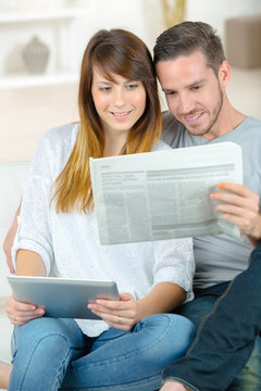 couple reading news from different source