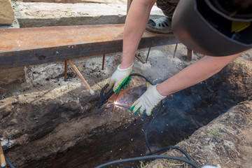 Worker welds metal at the construction site