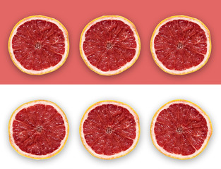 Grapefruit Slices On The Pink and White Background