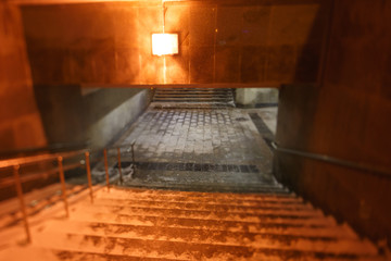 Fototapeta na wymiar Moscow, Russia. Stone staircase in the underground crossing. The transition is finished with granite slabs. Wet footprints on the floor