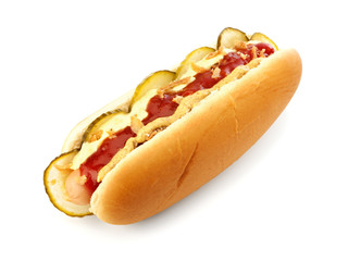 Classic danish hot dog with ketchup, mustard, cucumber slices and roasted onions isolated on white background