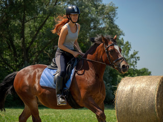 Frau model Rieterin reitet auf Pferd auf Wiese in der Natur bei Sonnenschein im Sommer