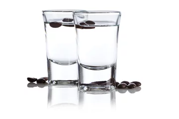 Photo sur Plexiglas Alcool Two shot glasses with Italian Sambuca hard liquor surrounded by coffee beans isolated on white background