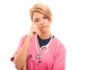 Portrait of female vet wearing pink scrub showing thinking gesture.