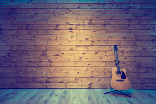 Acoustic guitar on wooden wall, music studio concept background Stock Photo  | Adobe Stock