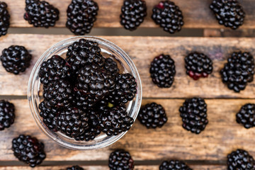 Fresh ripe blackberries in bowl on wooden table