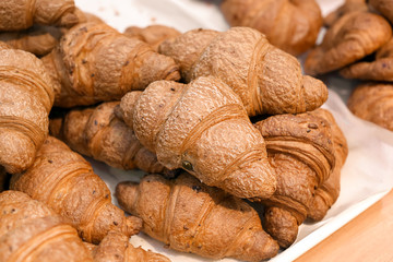 Fresh tasty croissants on display in bakery