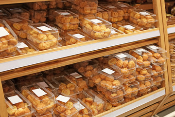 Fresh tasty pastry on shelves in shop
